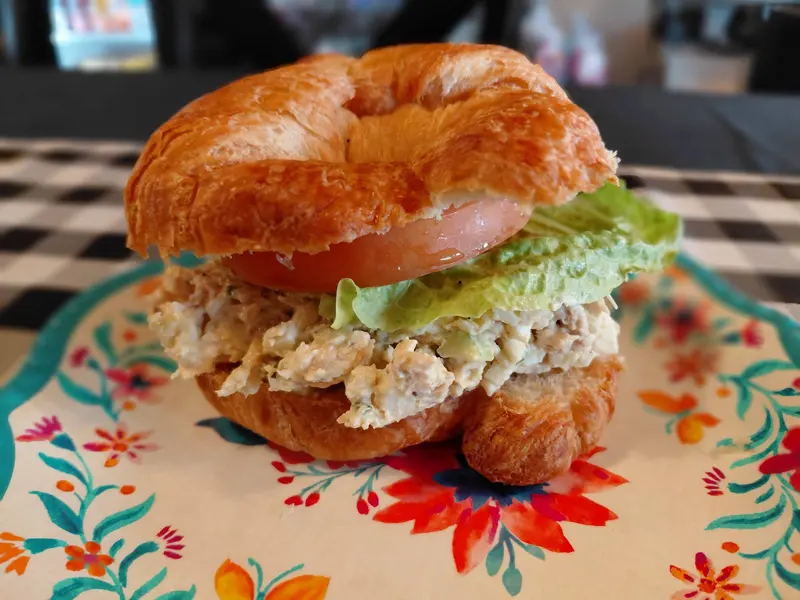 Homemade chicken salad piled on a croissant with lettuce and tomato